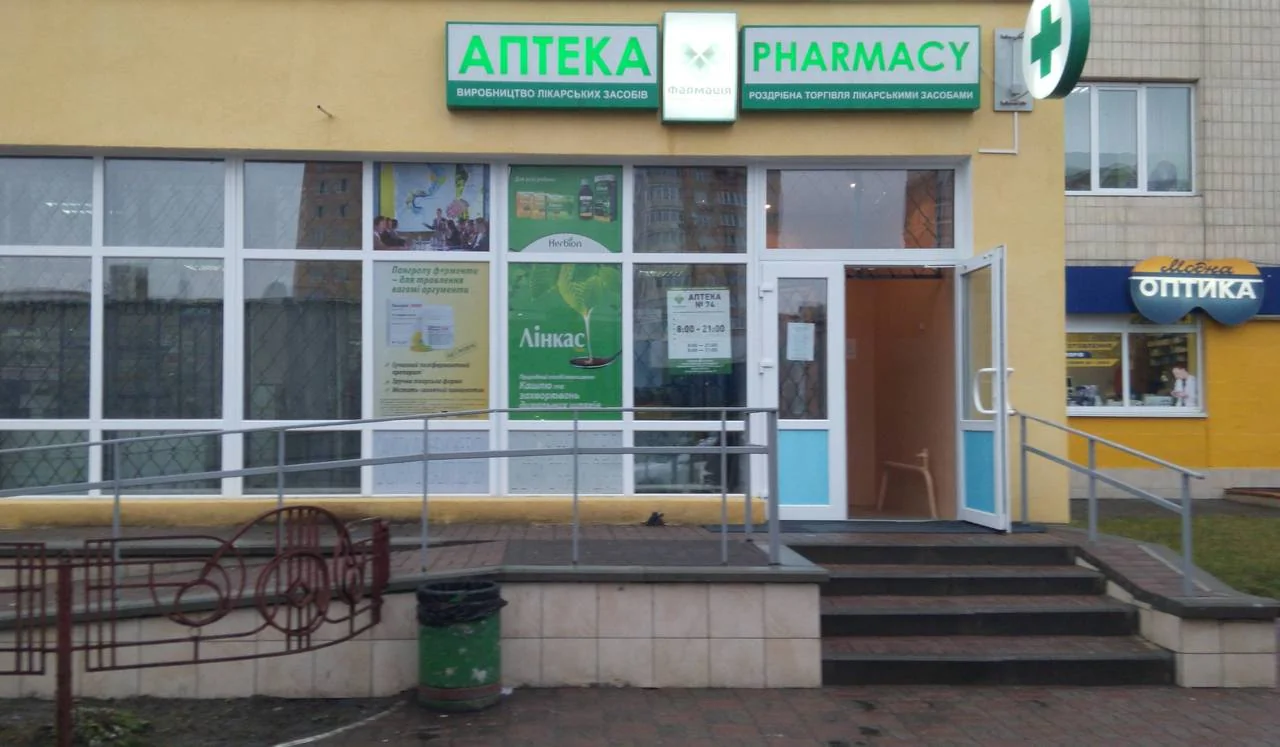 Фасад аптеки «Фармація» з вивісками АПТЕКА і PHARMACY, відкритим входом і пандусом
