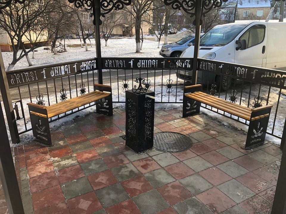 Кована альтанка з лавками та написом Ірпінь на площі взимку