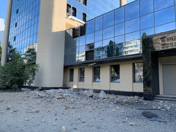 Пошкоджена адмінбудівля з вибитими вікнами та уламками на подвір’ї