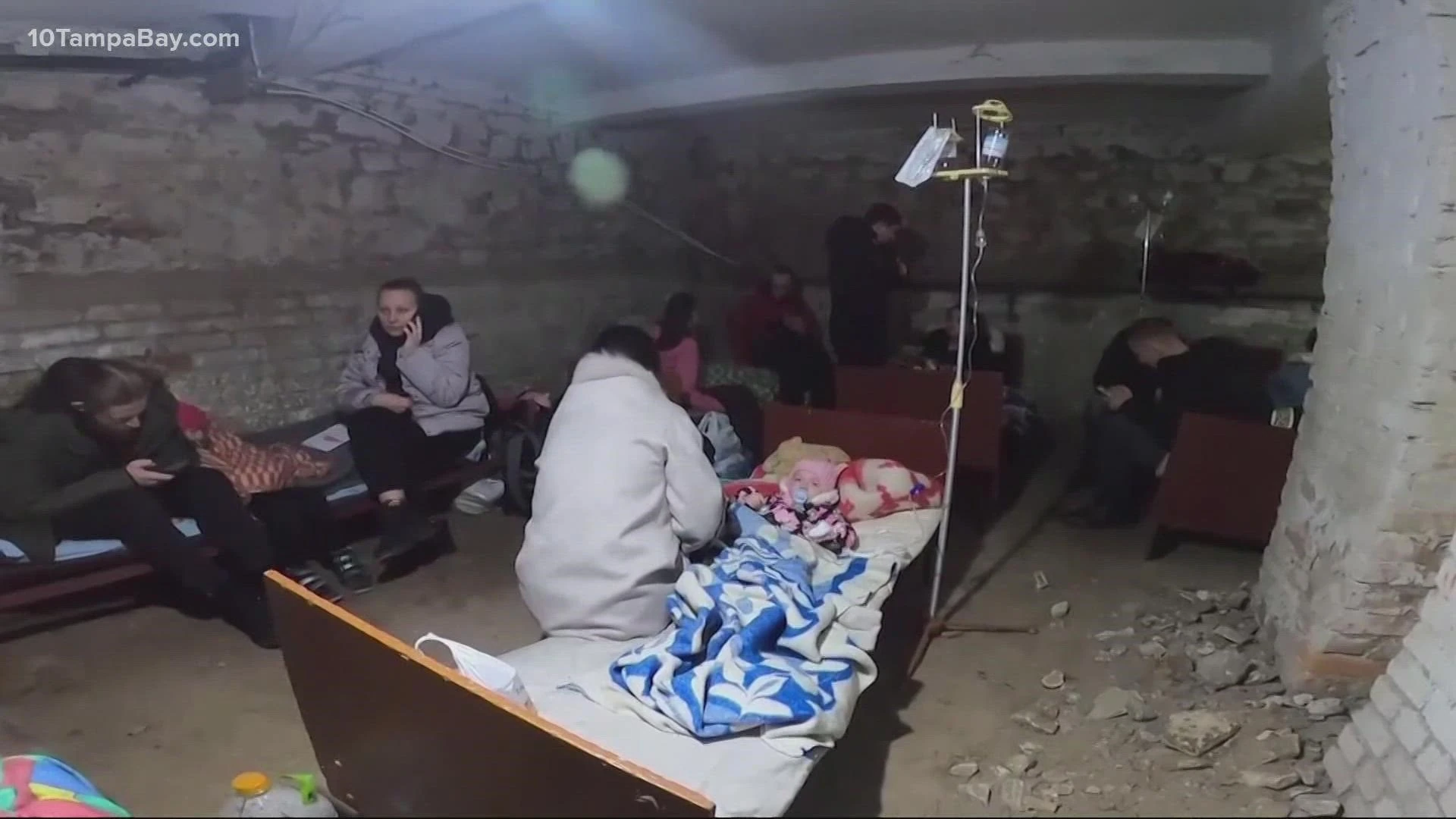 Люди в укритті під час повітряної тривоги, сидять на матрацах