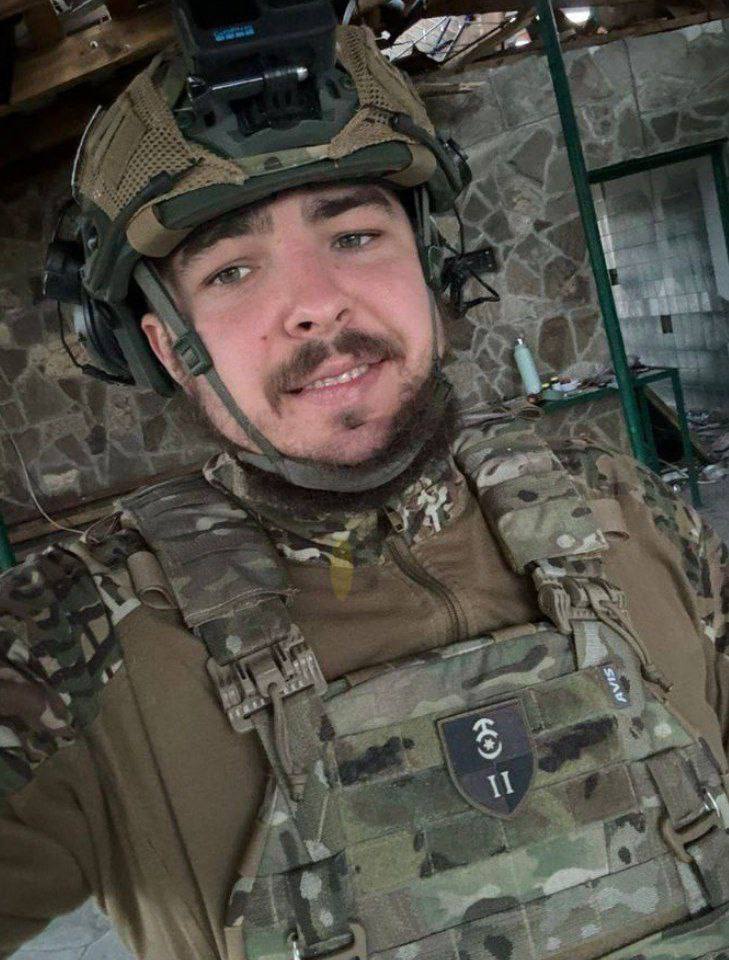 Військовий у камуфляжному шоломі та бронежилеті робить селфі в приміщенні
