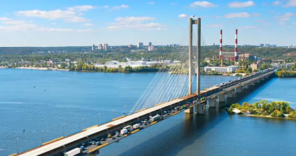 Південний міст через Дніпро з автотрафіком, містом і димарями на березі