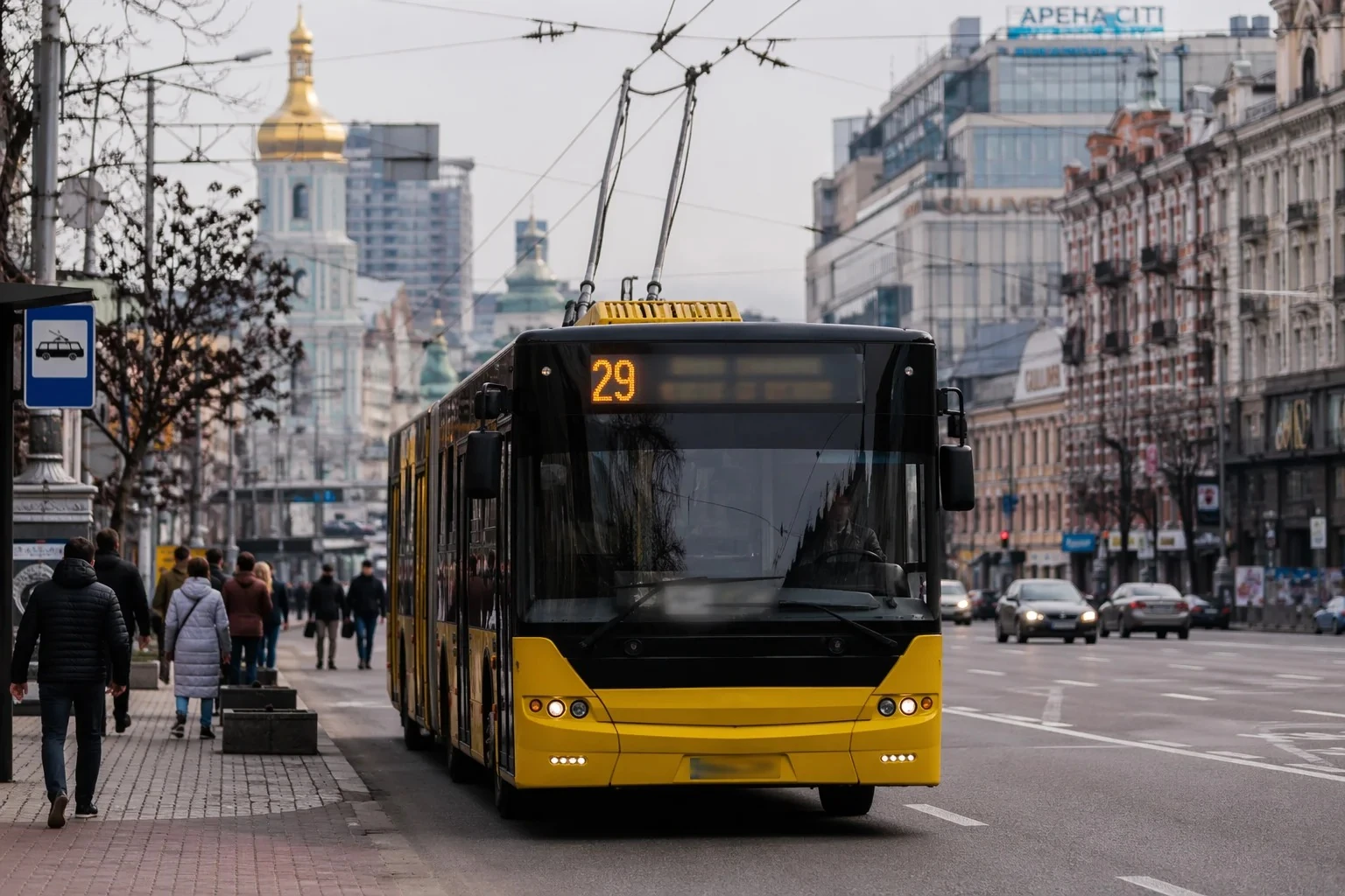 Жовтий тролейбус номер 29 на вулиці міста з людьми