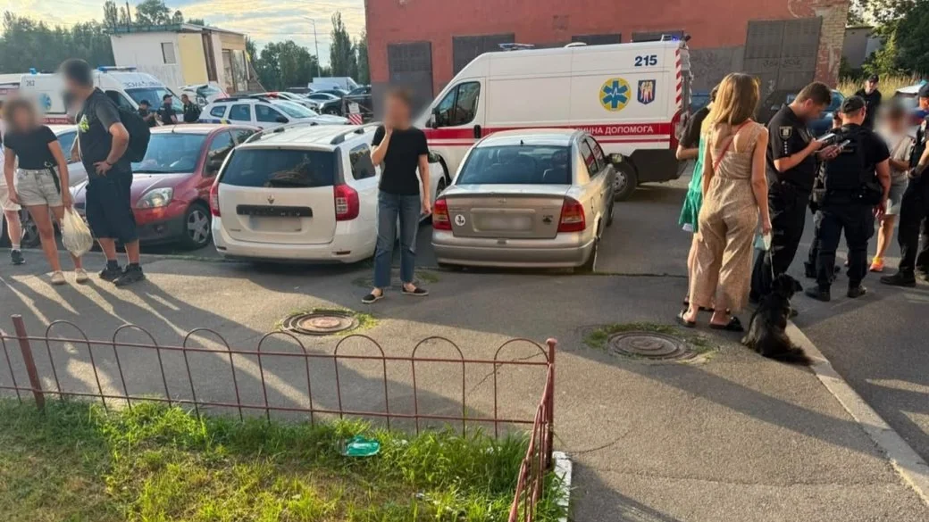 Поліція, швидка допомога і перехожі біля припаркованих авто на вулиці