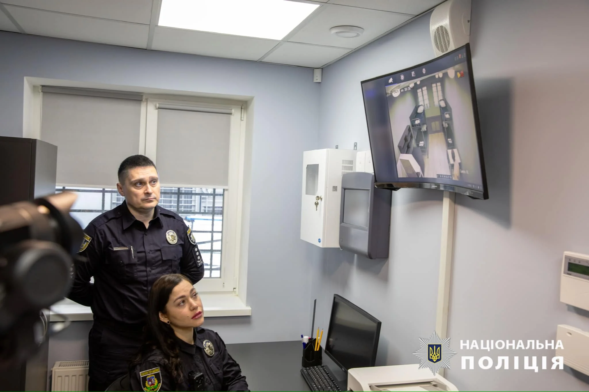 Поліцейські дивляться на монітор відеоспостереження в кабінеті відділку